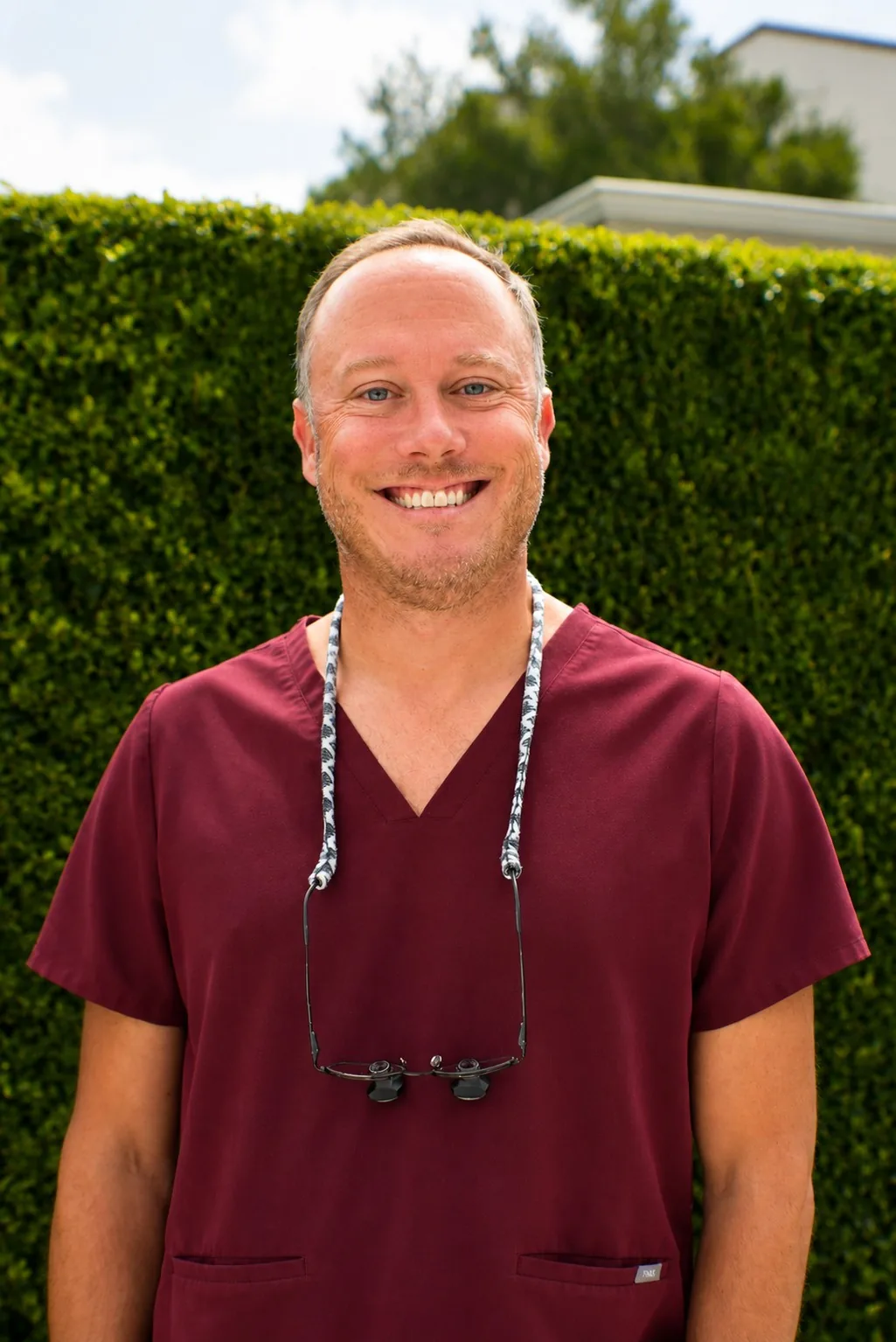 Dr. Ryan McCall, DDS, smiling outside the practice